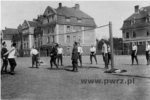 Żołnierze grający w siatkówkę na tle Gmachu Szkoły Podchorążych Wojsk Balonowych w Toruniu